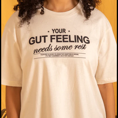 T-shirt creme com texto preto em fundo amarelo.