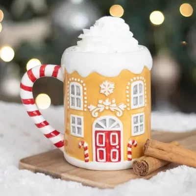 Caneca decorativa de casa de pão-de-espécie com chantilly e paus de canela