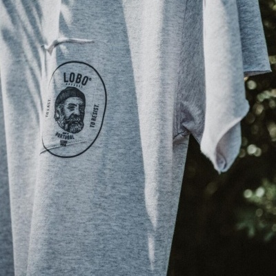 T-shirt cinzenta com estampa preta com rosto masculino e texto LOBO, TEXAS, PORTUGAL, TO RESET