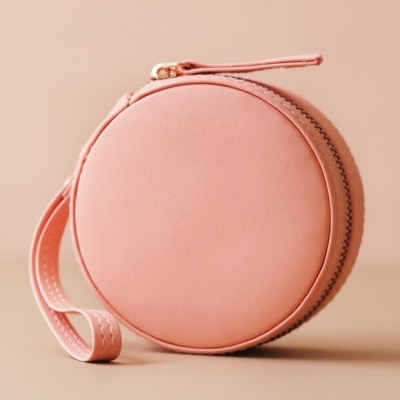 Bolsa circular cor de rosa clara com fecho dourado e alça de mão