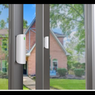 Sensor branco com luz verde num batente de porta de vidro