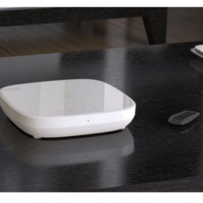 Dispositivo electrónico branco na mesa preta de madeira com objecto cinzento