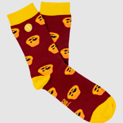 Meias vermelhas com detalhes amarelos e padrão de frutas alaranjadas.