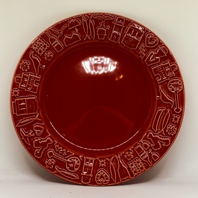 Prato redondo vermelho com relevo na borda de figuras diversas