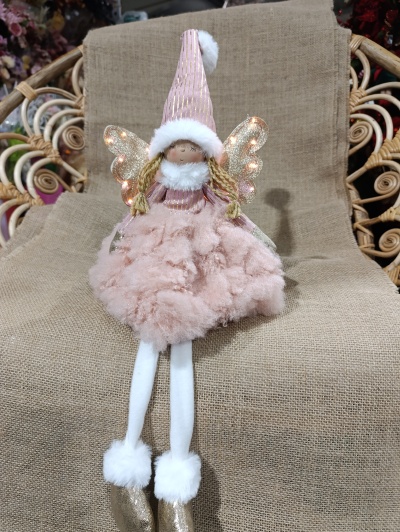 Menina Natal sentada com luz nas asas