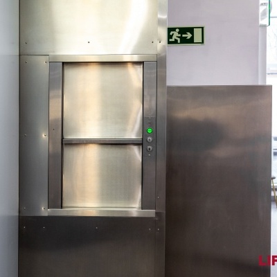 Elevador de serviço em aço inoxidável com botão verde e sinal de saída de emergência