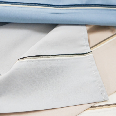 Tecidos em azul claro, cinza, bege e branco com linhas douradas e pretas