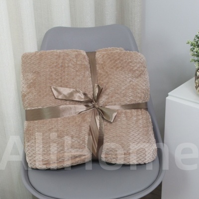 Manta bege claro com fita cetim sobre cadeira cinza
