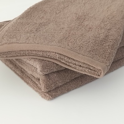 Toalhas castanho claro empilhadas sobre superfície branca