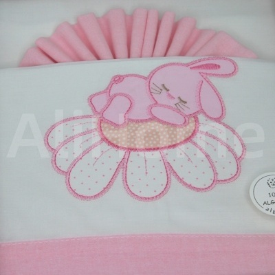 Roupa branca e rosa com bordado de coelho sobre flor e textura ondulada rosa