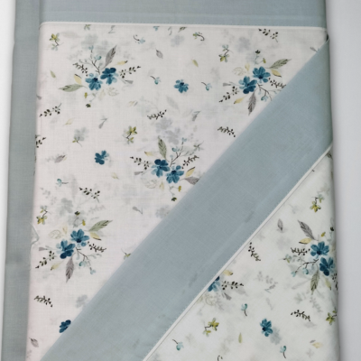 Toalha ou manta azul claro com padrão floral e bordas azuis