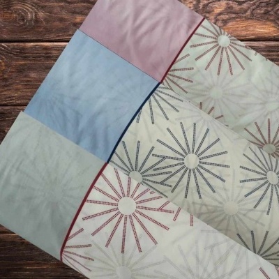 Três tecidos coloridos com padrão de estrelas sobre uma superfície de madeira