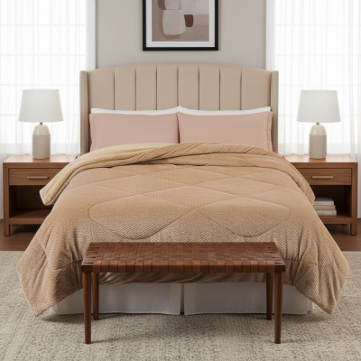 Quarto com cama de cabeceira estofada beige, roupa de cama beigel, mesas de cabeceira em madeira, candeeiros brancos e banco de madeira trançada
