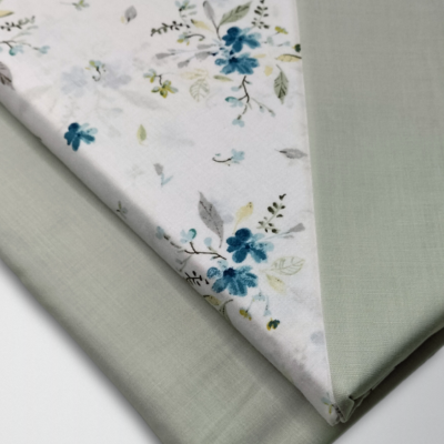 Tecido com padrão floral azul e verde e tecido verde claro dobrados