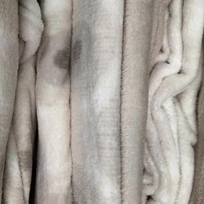 Tecido pelúcia em tons bege claro cinza com textura felpuda