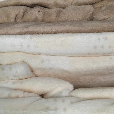 Mantas felpudas em tons neutros com padrão de pontos claros