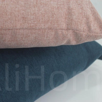 Duas almofadas, rosa claro e azul escuro, empilhadas sobre fundo branco