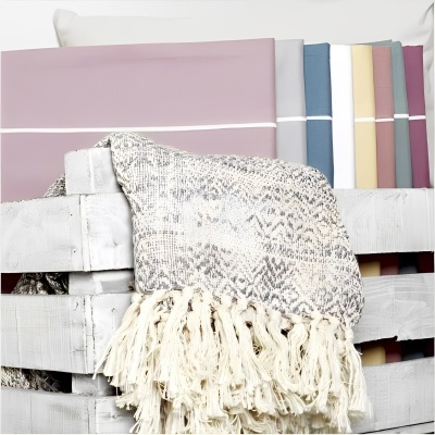 Mantais e toalhas coloridas numa caixa de madeira branca.