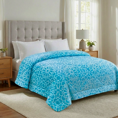 Cama com edredão azul com padrão floral branco num quarto com decoração clara e moderna
