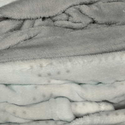 Cobertores felpudos cinza claro e branco com padrão de manchas