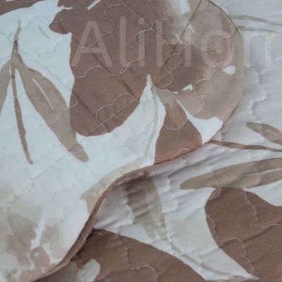 Cobertor acolchoado com padrão floral bege e castanho