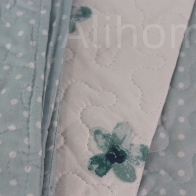 Tecido acolchoado cinza azul com bolinhas e tecido branco com padrão floral