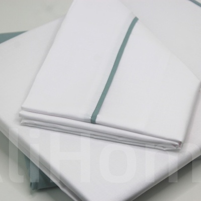 Conjunto roupa de cama branco com linha verde e texto AltHome