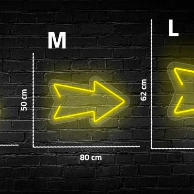 Três setas neón amarelas em vários tamanhos contra parede de tijolo preta