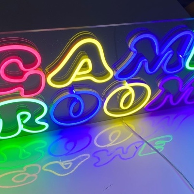 Luz de néon colorida com palavras 'GAME ROOM' em placa transparente