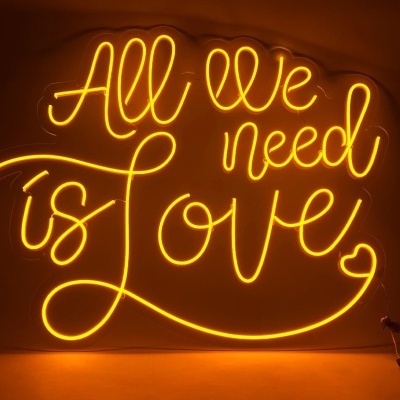 Sinal de néon amarelo com a frase All we need is Love