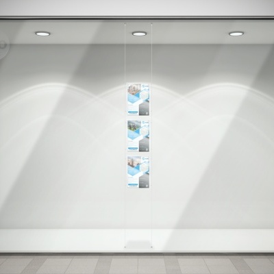 Vitrine de loja branca iluminada com três cartazes suspensos no centro