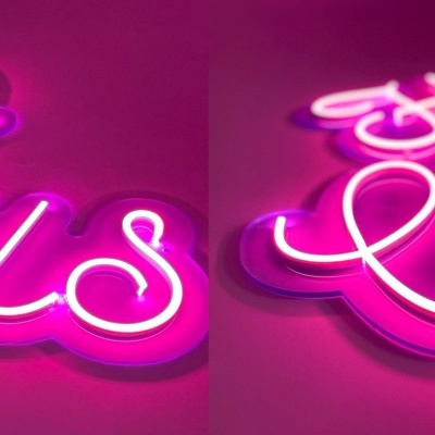 Placas de néon cor-de-rosa com texto cursivo luminoso num fundo cor-de-rosa