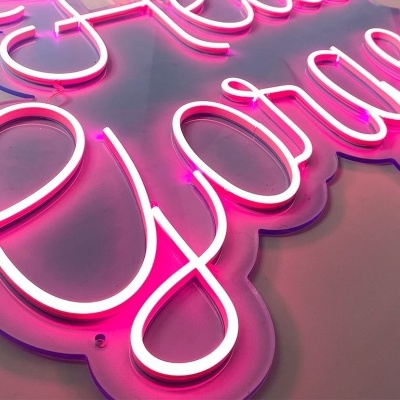Letreiro de neon cor-de-rosa em letras cursivas numa base transparente