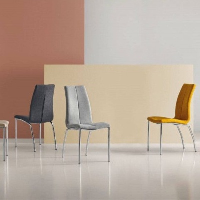 Cinco cadeiras estofadas coloridas com pernas metálicas em ambiente minimalista