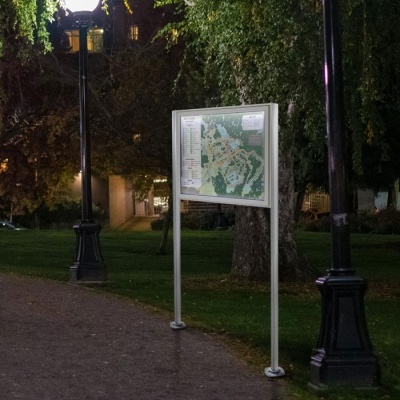 Quadro de informação com mapa numa zona ajardinada à noite