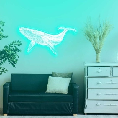 Sala com sofá preto, cómoda branca, candeeiro de pé e decoração de baleia luminosa na parede azul.