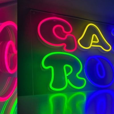 Letreiro de néon colorido dizendo GAME ROOM com reflexo