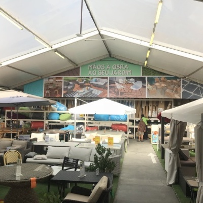Loja de móveis e acessórios para jardim com várias mobílias e guarda-sóis sob tenda com teto transparente