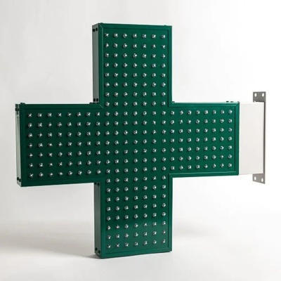 Sinal verde em forma de cruz com pequenos refletores metálicos