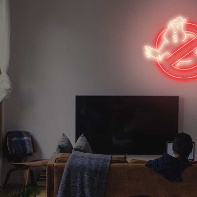Sala de estar com sofá, TV, lâmpada e luz de néon vermelha de Ghostbusters