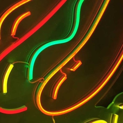 Neon colorido em forma de hot dog com texto parcial 'DOG'