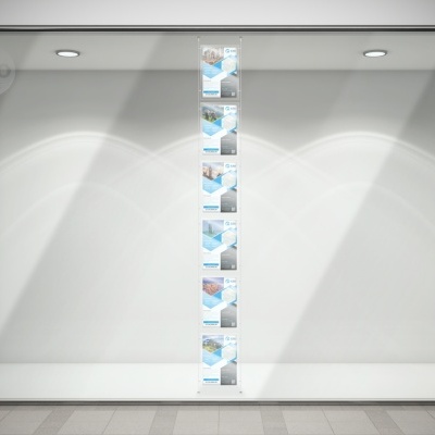 Vitrine de loja iluminada com cartazes verticais ao centro, fundo branco e piso cinzento