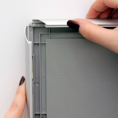 Mãos a abrir caixa plástica cinza e branca