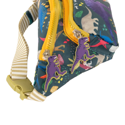 Bolsa tipo pochete com padrão de dinossauros coloridos e fechos amarelos com puxadores roxos