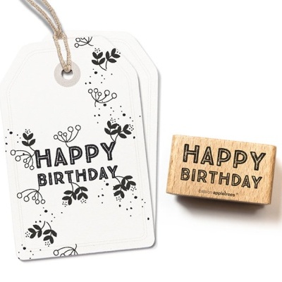 Carimbo de madeira com texto 'HAPPY BIRTHDAY' e etiqueta decorada com flores e texto correspondente