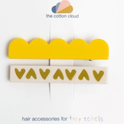 Acessórios para cabelo amarelo e branco com padrão de corações sobre cartão com texto