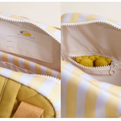 Interior de mochila riscada amarelo e branco com fecho e bolso interior