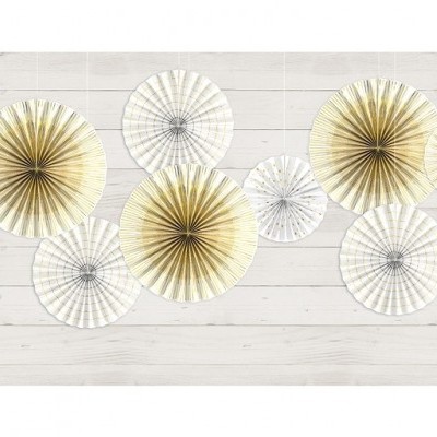 Leques decorativos redondos em tons branco, bege e dourado numa parede de madeira clara