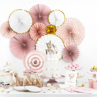 Decoração de festa com leques de papel rosa, branco e dourado e bolo 