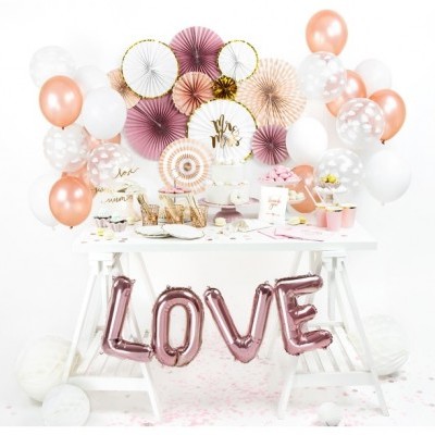 Mesa festiva com decoração de balões e leques, e balões metálicos 'LOVE'